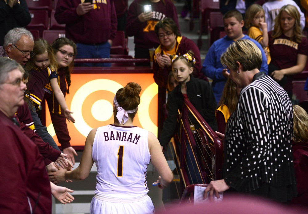 Rachel Banham gives high-fives to fans as she leaves the floor of Williams Arena for the last time. Despite Banham leading the team in scoring with 37 points,  the Gophers fell to south Dakota 101-89 in the second round of the WNIT.