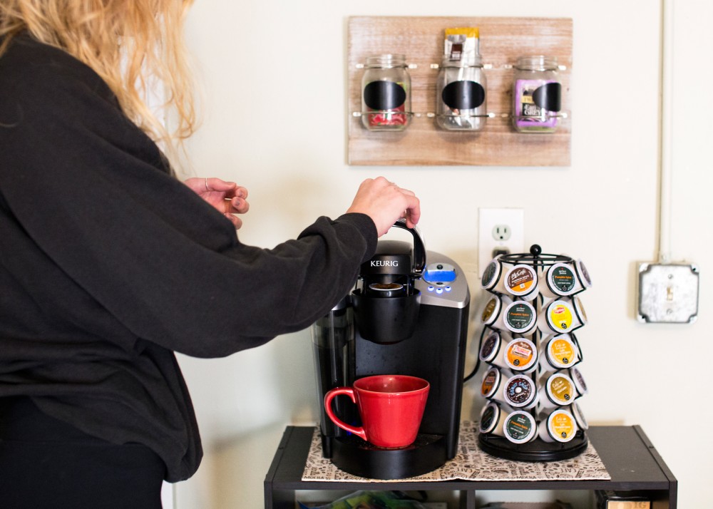 Sophomore Cece Sjoquist places a K-Cup in the Keurig she shares with her roommates in her Dinkytown apartment on Monday.