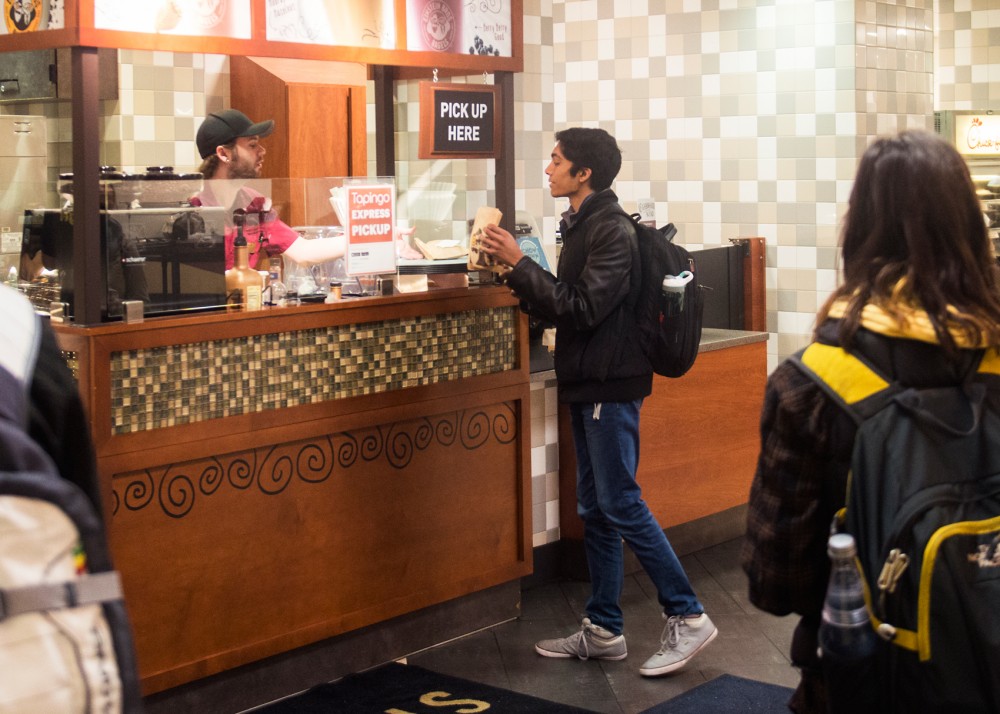 Freshman Vishnu Arun picks up his Tapingo order at Einstein Bros. Bagels in Coffman Memorial Unions Minnesota Marketplace on Wednesday morning. Arun has been using Tapingo for a month and said that he finds the app useful.