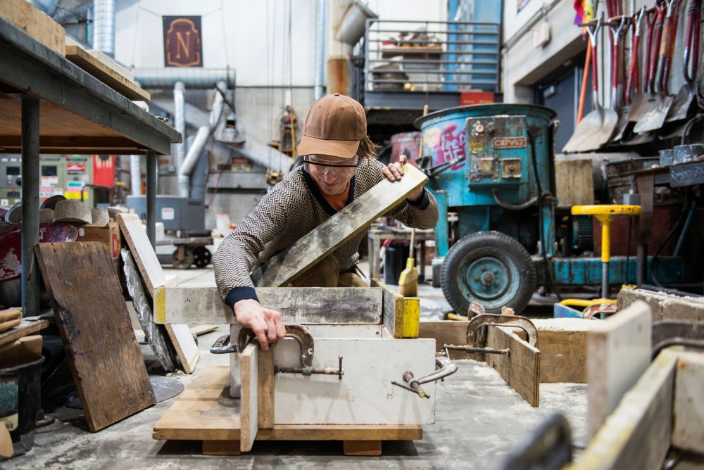 Junior Zachary Swenson, a BFA student, builds sand molds on Monday night for the 47th annual Iron Pour at the Foundry, located in the Regis Center for Art. At the event, molten iron will be poured into these molds to created cast iron sculptures.