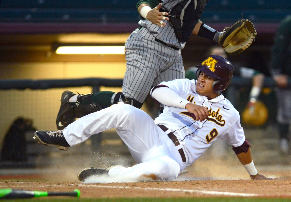 Freshman infielder Eddie Estrada slides through home plate at Siebert Field on Tuesday. After six innings with no runs during a game versus North Dakota State, the Gophers scored seven runs in the seventh inning, later closing the match 10-0. 