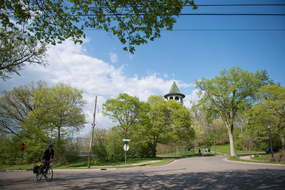 A woman bikes past the witchs tower on southeast Orlin avenue  Tuesday Afternoon. Although about half of the neighborhood is made up of students, currently no student is part of the Prospect Park Association. 
