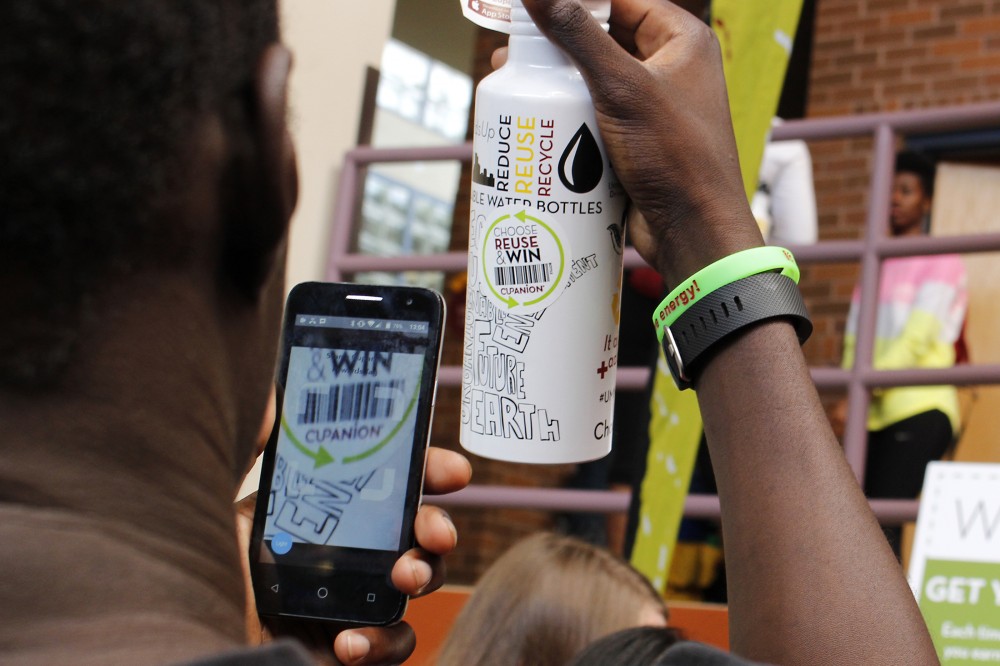A student scans a special sticker using the Cupanion app to earn points for refilling a reusable water bottle during Welcome Week on St. Paul Campus on Friday, Sept. 2. 