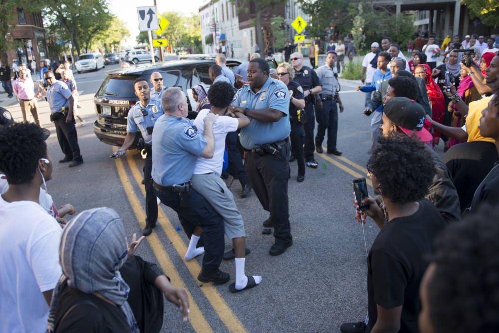 Officers struggle with an atteedee on Saturday, Sept. 10, 2016 in Cedar Riverside neighborhood.