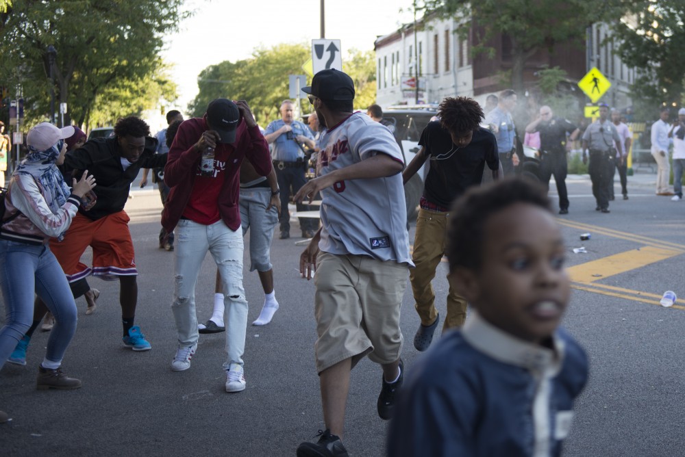 Members of the crowd and protestors flee the event area when officers being to spray on Saturday, Sept. 10, 2016 in Cedar Riverside neighborhood.