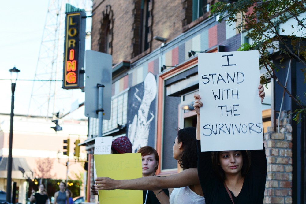 Demonstrator Bella Looney holds a sign in alliance with sexual assault survivors in front of the Loring Pasta Bar on Fourth Street on Saturday, Sept. 10, 2016 in Dinkytown. The protest was to raise awareness that Jason McLean, owner of Loring Pasta Bar and Varsity Theater, has four civil lawsuits alleging sexual abuse of minors at the Childrens Theater Company during the 70s and 80s, when he worked as an actor and teaching artist.