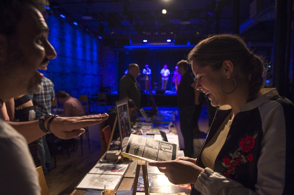 Savannah Reising speaks with Artist Carlos Merino about his comic art while performers hit the stage on Saturday, Sept. 10, 2016 at the Bedlam Theater in St. Paul, Minnesota.