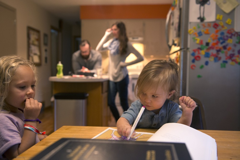 5-year-old Clara watches her 18-month-old E.J. color on Thursday, Sept. 15, 2016 at their home in Sartell, MN. University of Minnesota third year law student Edward Teddy Fleming, back left, had testified in March to help a bill pass to modify child care grant eligibility to include graduate students. Him and his fiancé Annabelle Stalboerger spend about $18,000 per year on child care expenses. 
