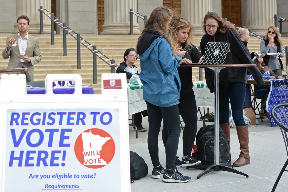 Strategic communications sophomores Maja Cave, left, and Marisa White, center, register to vote with the online software TurboVote with help from MSA member Cara Nix, right, at Voterpalooza hosted by MSA on Tuesday, Sept 27, 2016 at Northrop Plaza. MSA decided to use TurboVote this year to increase student registration on campus for the upcoming election. 