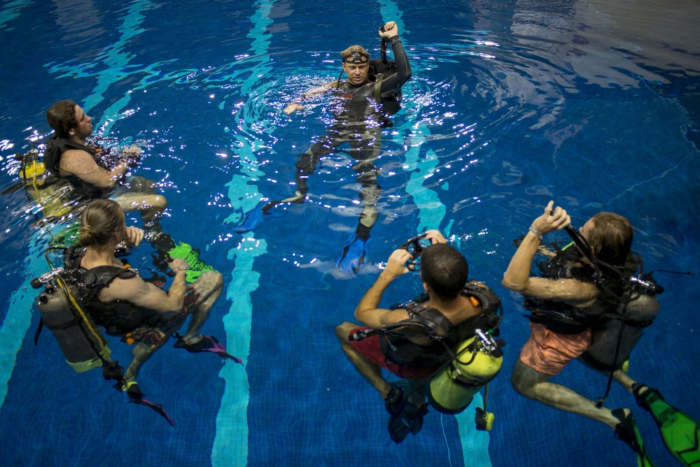 Instructor Andy Leidel holds up and explains to students how to use there buoyancy compensator device on Sept. 21, 2016, at the University Aquatic Center. The BCD device allows divers to stay buoyant underwater as well as on the surface.