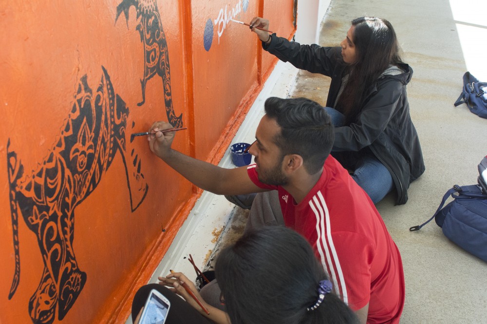 Neuroscience senior Santana Varghese, left,  physiology junior Vasanth Lakshmipathy, center, and biology junior Soumya Marasakatla, right, paint a mural for Bharat in the Washington Avenue Bridge on Friday, Sept. 30, 2016. 