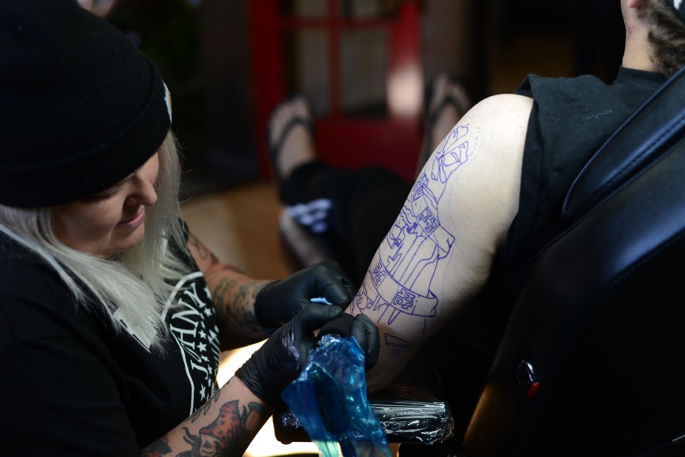 Shop owner and tattoo artist Nikki Time tattoos the first few lines on client Dan Wade at MPLS Tattoo Shop on Friday, Sept. 30, 2016 in Minneapolis.