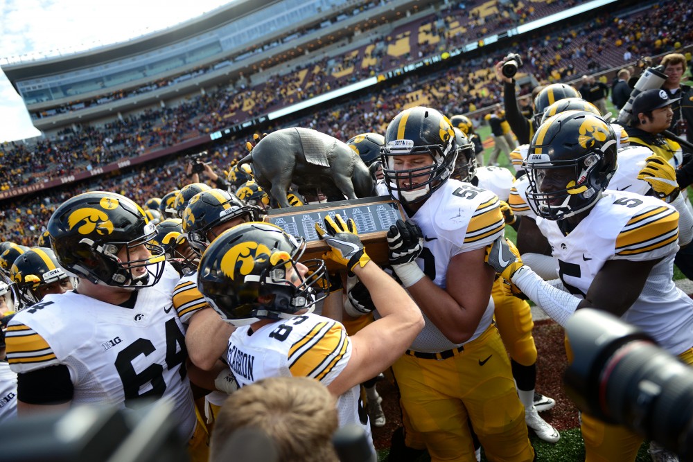 The Hawkeyes celebrate their win over the Gophers, carrying the Floyd of Rosedale rivalry trophy across the field on Saturday, Oct. 8, 2016 at TCF Bank Stadium.
