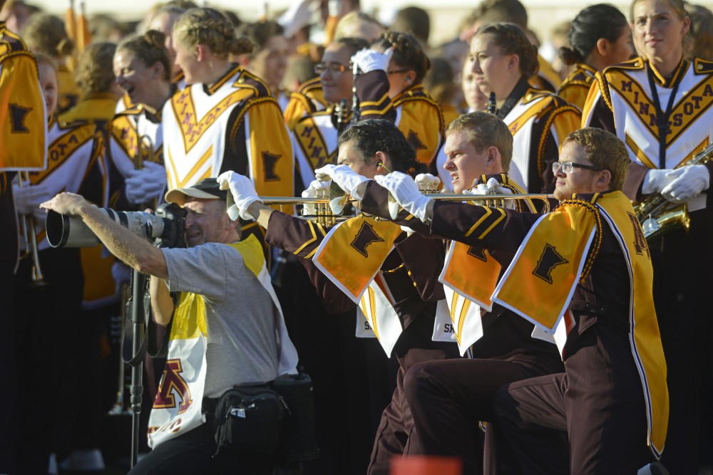 Members of the University of Minnesota Marching Band imitate a photographer before halftime at TCF Bank Stadium on Nov. 5, 2016. 