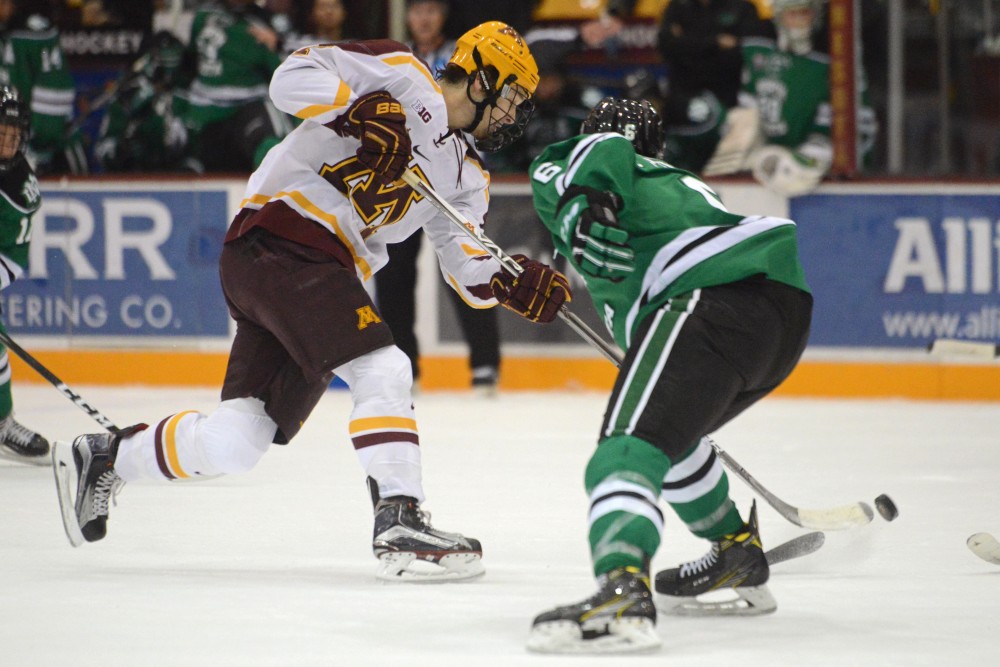 Gophers forward Tommy Novak sneaks the puck around North Dakota on Friday, Nov. 4, 2016 at Mariucci Arena. The Gophers tied 5-5 against the Fighting Hawks.