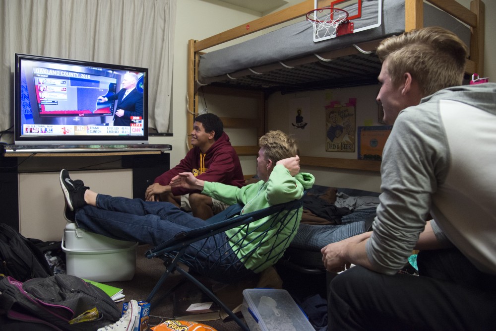 Kinesiology freshman Isaiah Wills, left, Economics freshman Larson Cole, center, and Computer Engineering freshman Jake Knecht follow election results in a Territorial Hall dorm room on Tuesday, Nov. 8, 2016. 