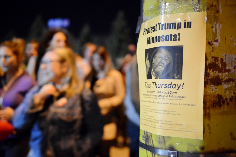 A poster taped to a traffic light describes the protest held on Thursday, Nov. 10, 2016. Protesters walk past it as they return to Humphrey School of Public Affairs on West Bank in Minneapolis. Protesters shut down I-94 in response to Donald Trumps election.