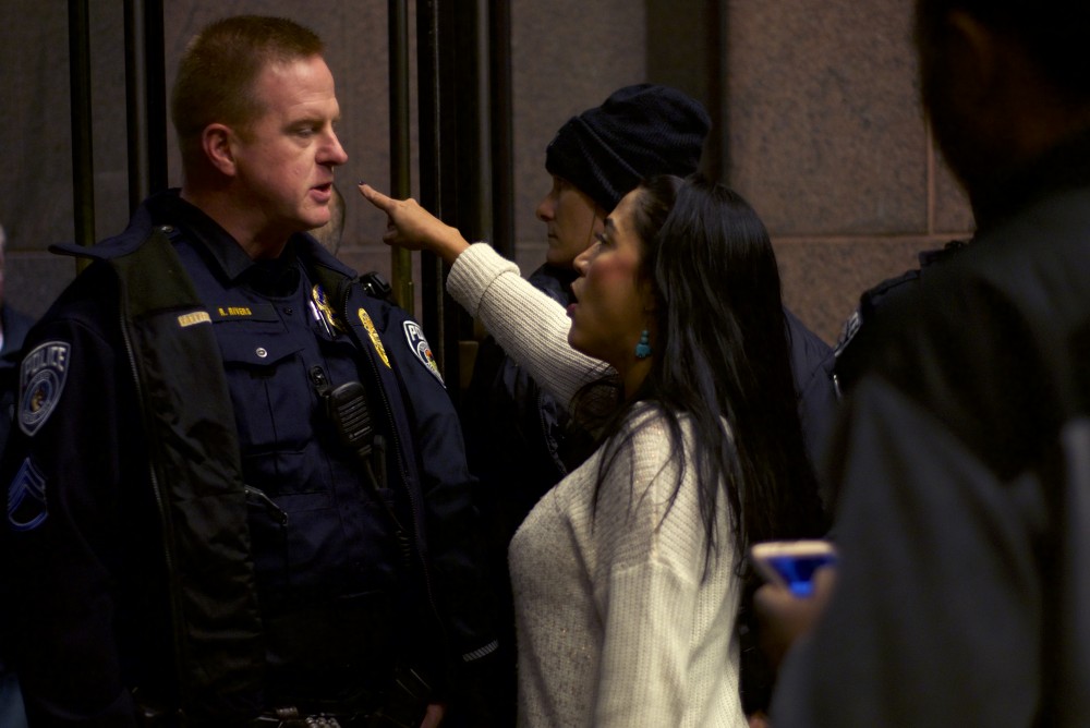 Adriana Cerrillo confronts an officer outside the McNamara Alumni Center on Thursday, Nov. 10, 2016. Cerrillo went outside the event to check in with protestors and was then not let back inside.