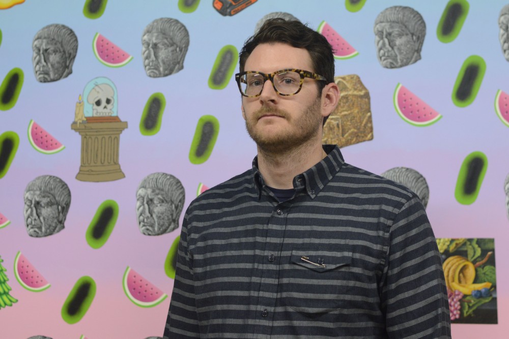Mathew Zefeldt poses for a portrait in front of one of his paintings during his gallery opening at the Soap Factory in Minneapolis on Nov. 12, 2016. Zefeldt, a University assistant professor of art, will have his exhibition Desktop on display until Dec. 18, 2016.