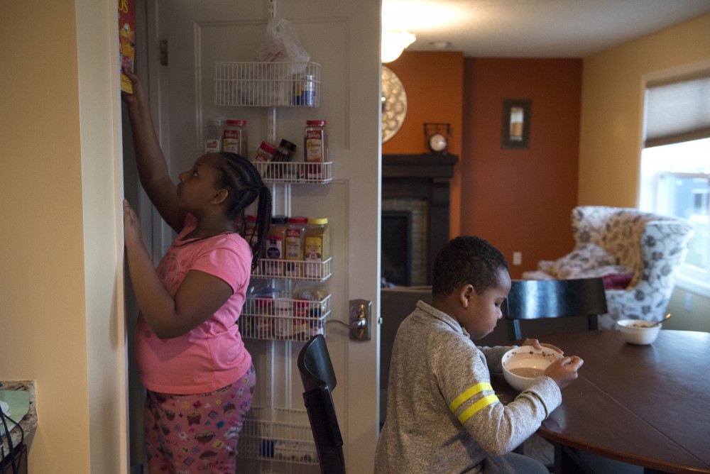 Aslaa puts a box of cereal away after making Ayub breakfast on Monday, Nov. 14, 2016 at their home in Savage, Minnesota. Aslaa helps her mother closely with her sister and brothers morning routines. 