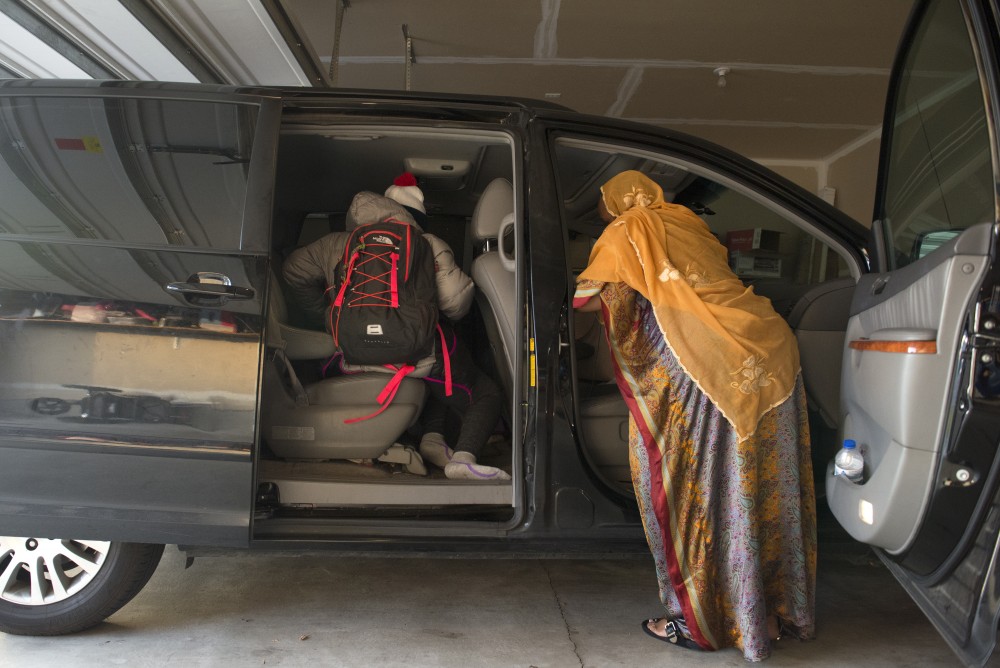 Marian Ahmed helps her children into the van and prepares to drive them to school on Monday, Nov. 14, 2016 at their home in Savage, Minnesota.  