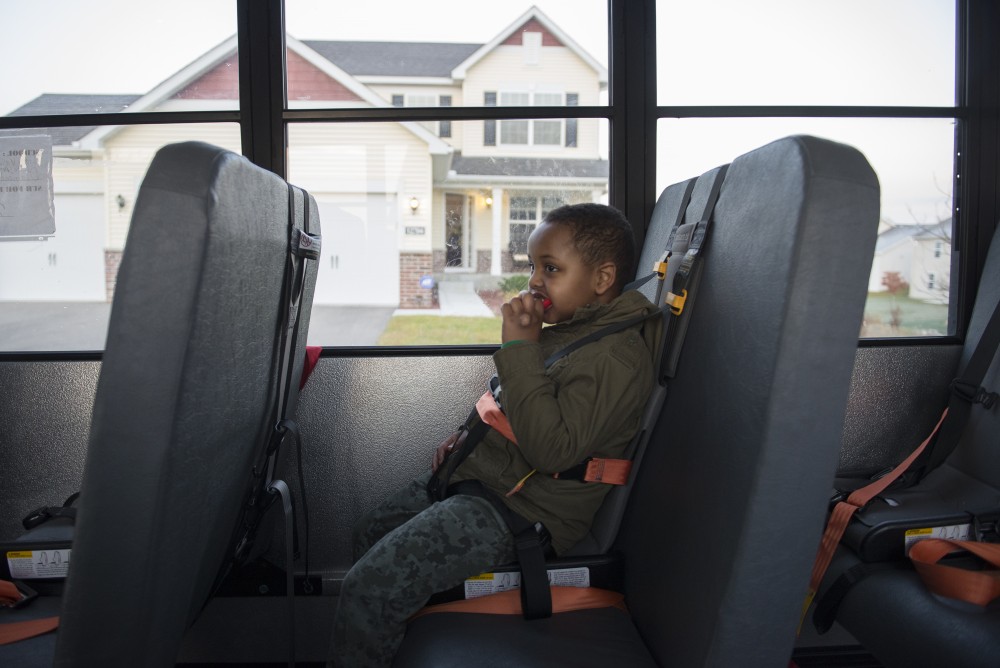 Anas sits on the bus parked outside his house, chewing on his sensory toy on Monday, Nov. 14, 2016 outside their home in Savage, Minnesota. The toy helps with his sensory processing issue and prevents him from biting objects. 