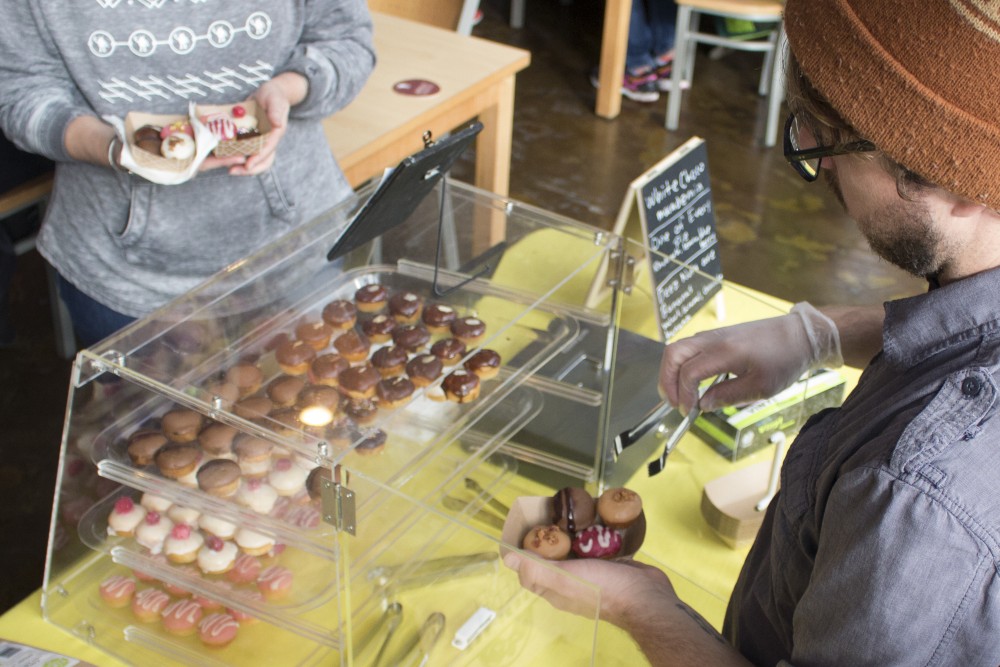 Vince Traver, owner of Rebel Donut Bar, sells mini donuts to customers at Tin Whiskers Brewery in St. Paul on Saturday, Nov. 19, 2016.