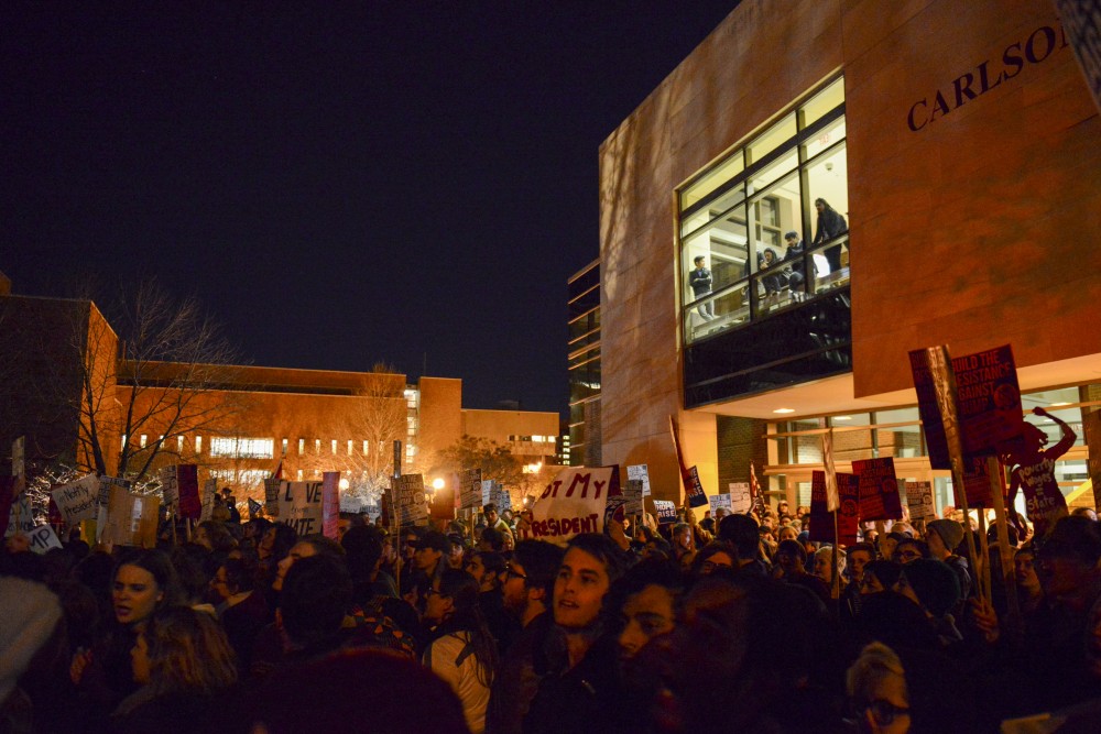 Bystanders watch as protesters gather outside Humphrey School of Public Affairs on West Bank in Minneapolis on Thursday, Nov. 10, 2016. Protesters shut down I-94 in response to Donald Trumps election.