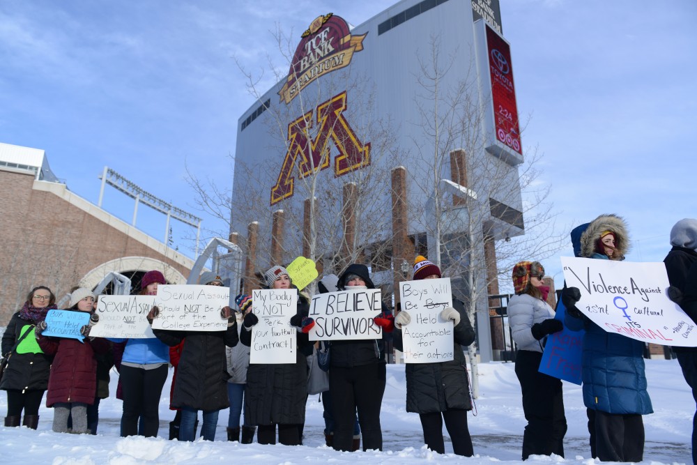 Protesters stand in front of TCF Bank Stadium on Sat. Dec. 17, 2016. After 10 Gophers football players were suspended for sexual assault, the Gophers football team boycotted playing in the holiday bowl until the suspensions were lifted. 
