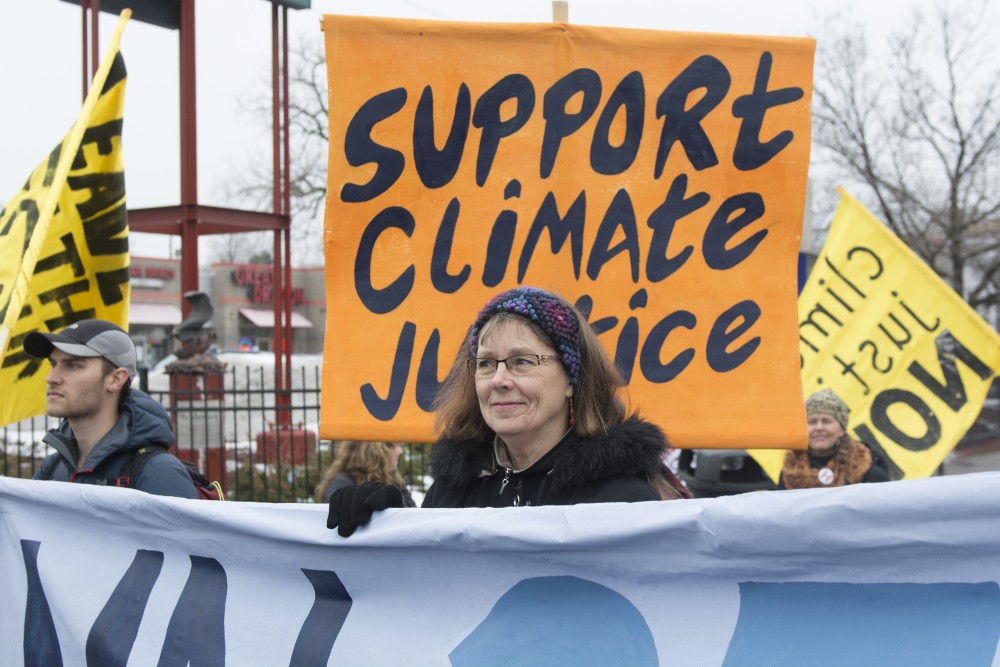 Kathy Hollander holds a banner during a protest of Donald Trumps inauguration on January 20, 2017. Trumps cabinet appointees arent good for climate change, Hollander said. My generation is responsible for giving back. 