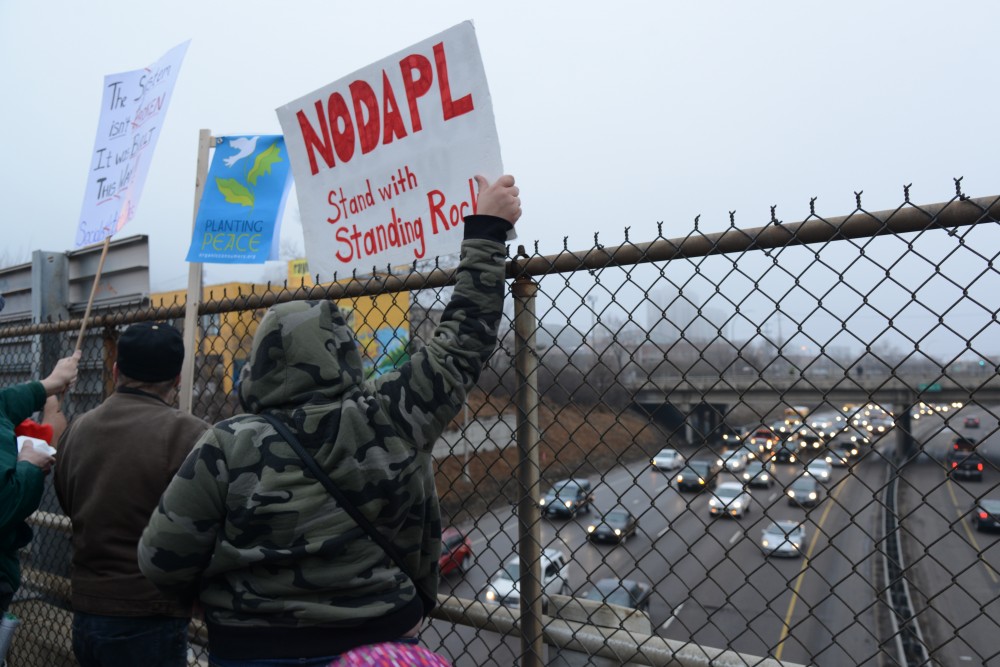 Protesters hold signs up to traffic during their march on Friday, Jan. 20, 2017. 