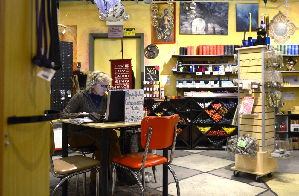Psychic Holly Burns sits at a table in Magus Books and Herbs awaiting customers to give readings to on Jan. 25, 2016. Magus, located in Dinkytown, offers a variety of spiritual services to the Minneapolis community. 