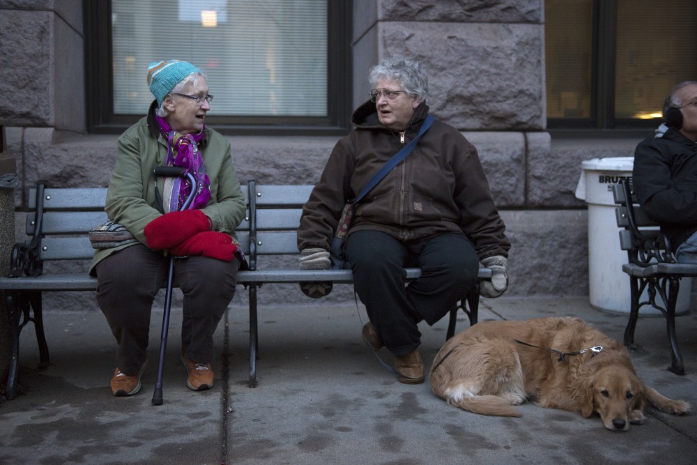 Catherine Farrell, Bonnie Urfer and dog Camper chat on the outskirts of a rally against President Donald Trumps immigration policy in Minneapolis on Tuesday, Jan. 31, 2017. Urfer drove an hour and a half from Wisconsin but said shed protest every night if she could.  You need to bring a whiteboard sign to these things because theres an issue everyday, she said. 