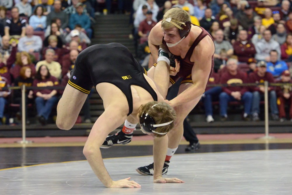 Senior Brett Pfarr takes on Iowas Cash Wilcke at the Sports Pavilion on Sunday, Feb. 5. The Gophers lost 11-27 against the University of Iowa Hawkeyes.