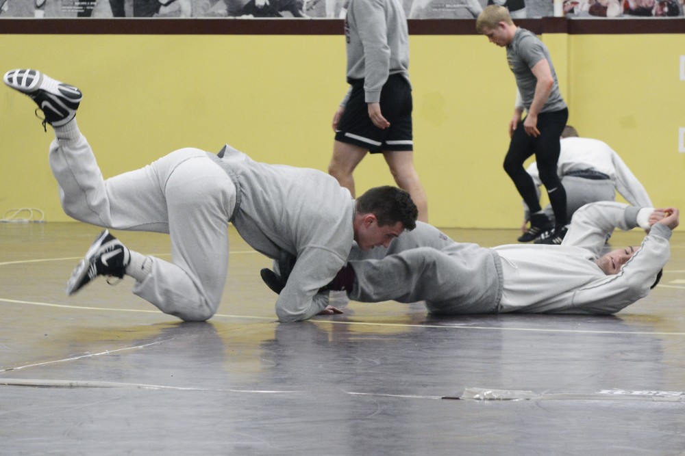 Ben Brancale, center, practices with teammate Jake Short, right, at the Bierman Athletic Building on Wednesday, Feb. 1, 2017. Wrestlers often practice two to three times each week with the same partner.