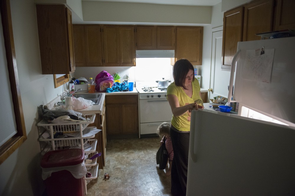 Ashley Crook peers into the fridge while her daughter, Charlotte, stands behind her in the Glendale Community Townhomes on Friday, Feb. 3, 2017. 