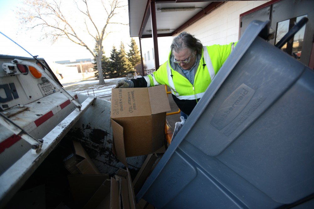 Russ Pert unloads a container of cardboard into his truck at the Como Recycling Facility in Minneapolis on Friday, Feb. 3, 2017.