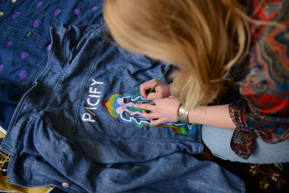 Maddie Bolatto paints a jacket for local clothing brand, Pacify. The brand, created by three local female artists, focuses on creating original pieces from thrifted clothing.