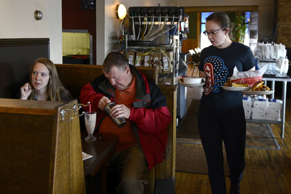 Emma Fowler delivers food to Russ and Joan Peih and Grace Hausker, at Annies Parlour on Monday, February 27, 2017 in Dinkytown.