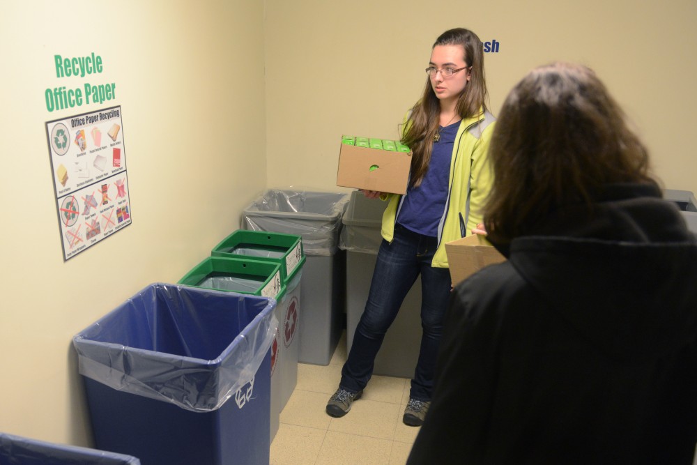 Environmental science and management sophomore Claudia Althoen looks over the organics bins placed in the trash room in Yudof Hall on East Bank on Friday, March 10, 2017.