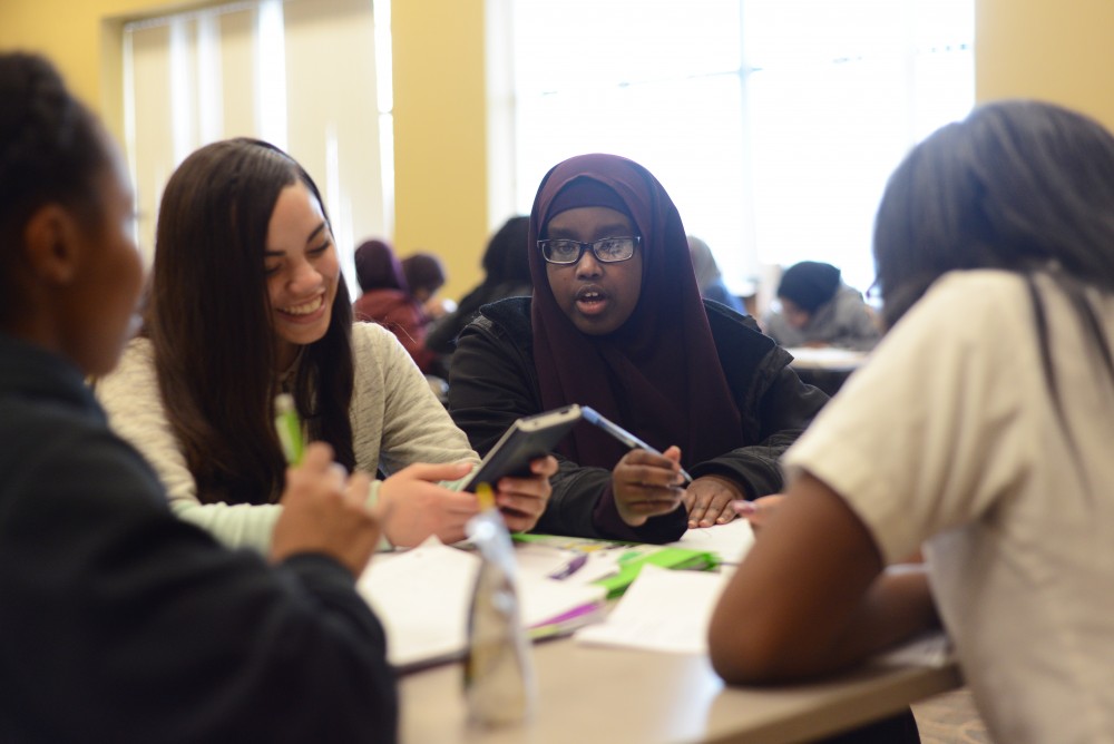 University of Minnesota mentor Zainab Mohamed works on algebra homework with a group of high school students on April 5, 2017 at the Universitys Urban Research and Outreach Engagement Center in Minneapolis. 