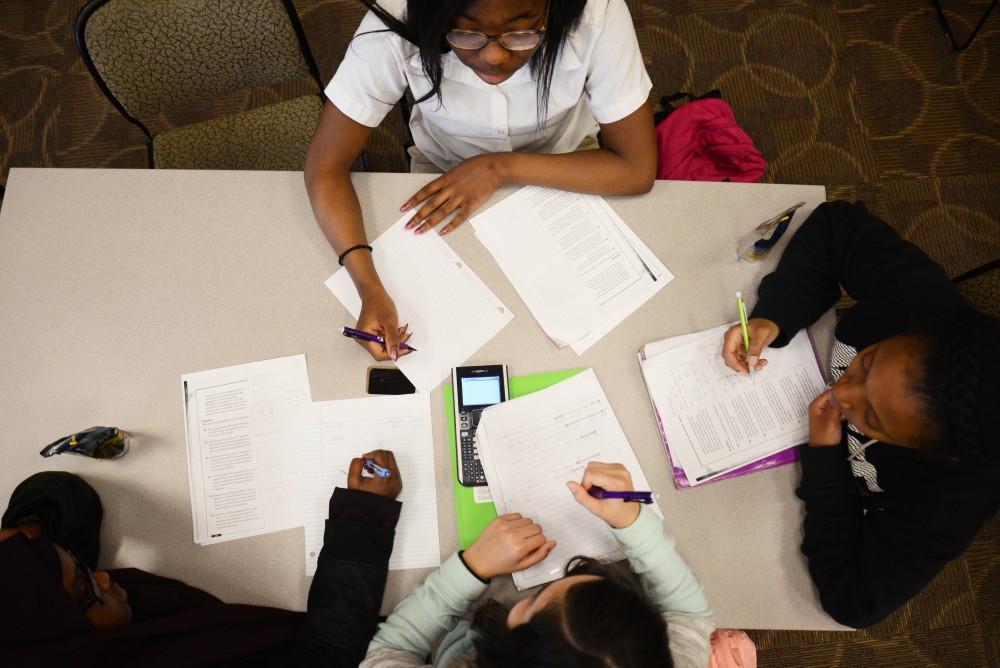 A group of high school students work on algebra homework with a University of Minnesota mentor on April 5, 2017 at the Universitys Urban Research and Outreach Engagement Center in Minneapolis. 
