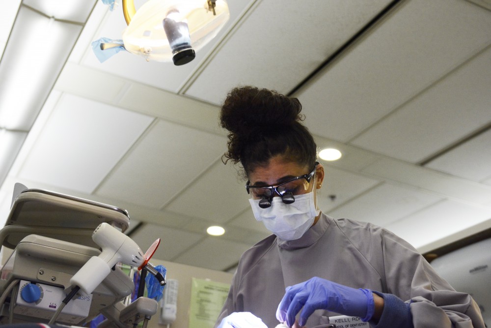 University of Minnesota dental student and dental hygienist Kelli Blankenship works on a patients teeth on April 14, 2017 in Moos Towers. Blankenship has used accommodations through the Disability Resource Center for nine years as she has worked toward her three degrees at the University of Minnesota. 