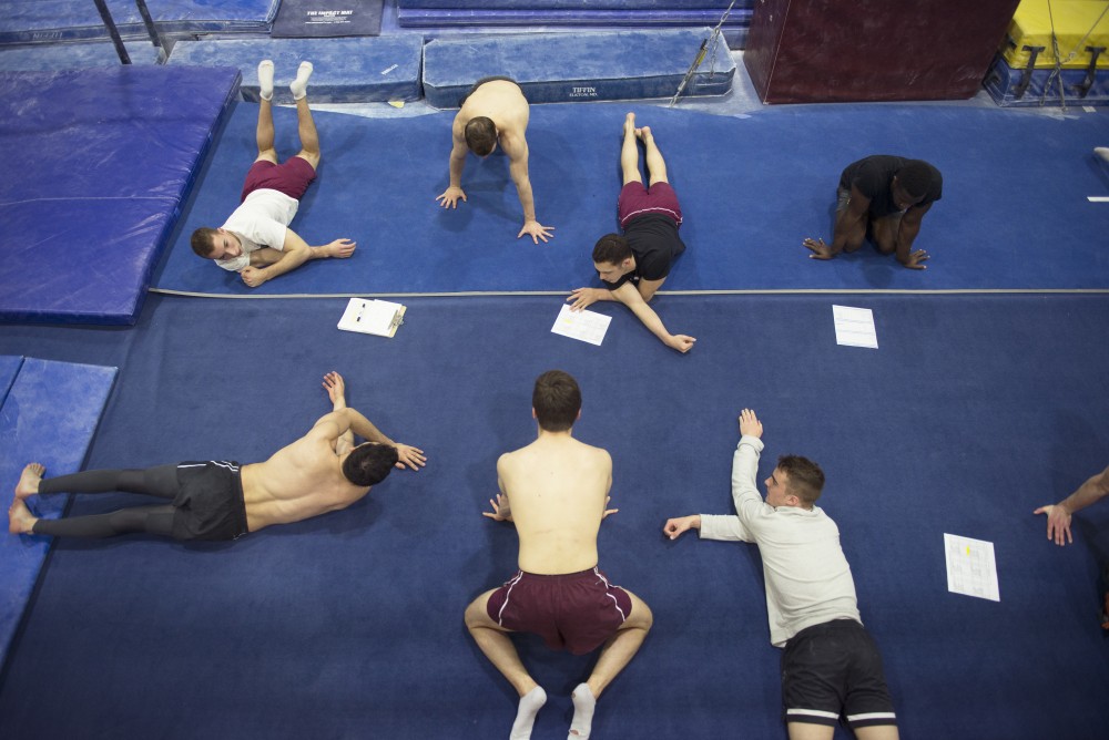 The Gophers Mens Gymnastic team stretches before practice in Cooke Hall on Wednesday, April 19, 2017.