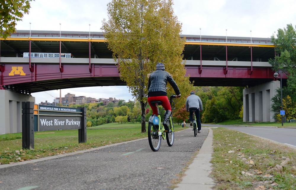 Pedestrians bike on the West River Parkway trail under Washington Avenue bridge on Saturday, Oct. 19, 2013. University students and faculty members disagree over whether to add concrete barriers to the sides to better prevent people jumping from the bridge. 