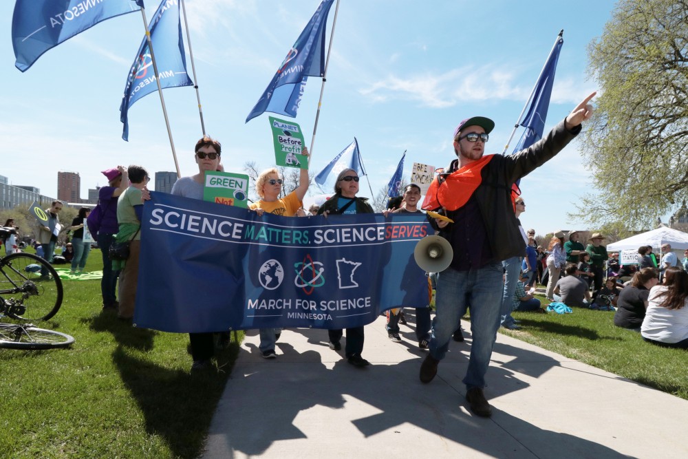 Chant leader Gabriel Berlovlitiz directs protesters on Saturday, April 22, 2017 in St. Paul. Thousands marched in solidarity across the nation to promote funding for scientific research.