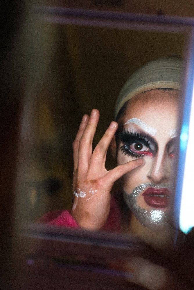 Masoudae Rezvani positions their fake eyelashes in their bedroom, transforming into their drag persona, Heda Thrasher.