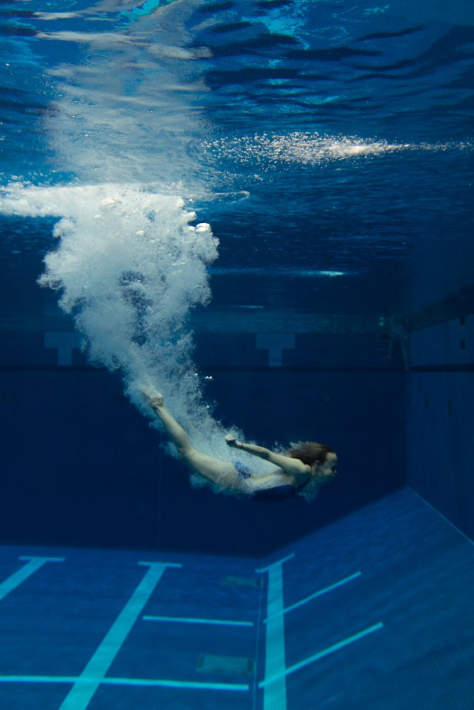 Out Back Diving diver Caitlyn Greenwalt dives into the deep-water pool at the University Aquatic Center.
