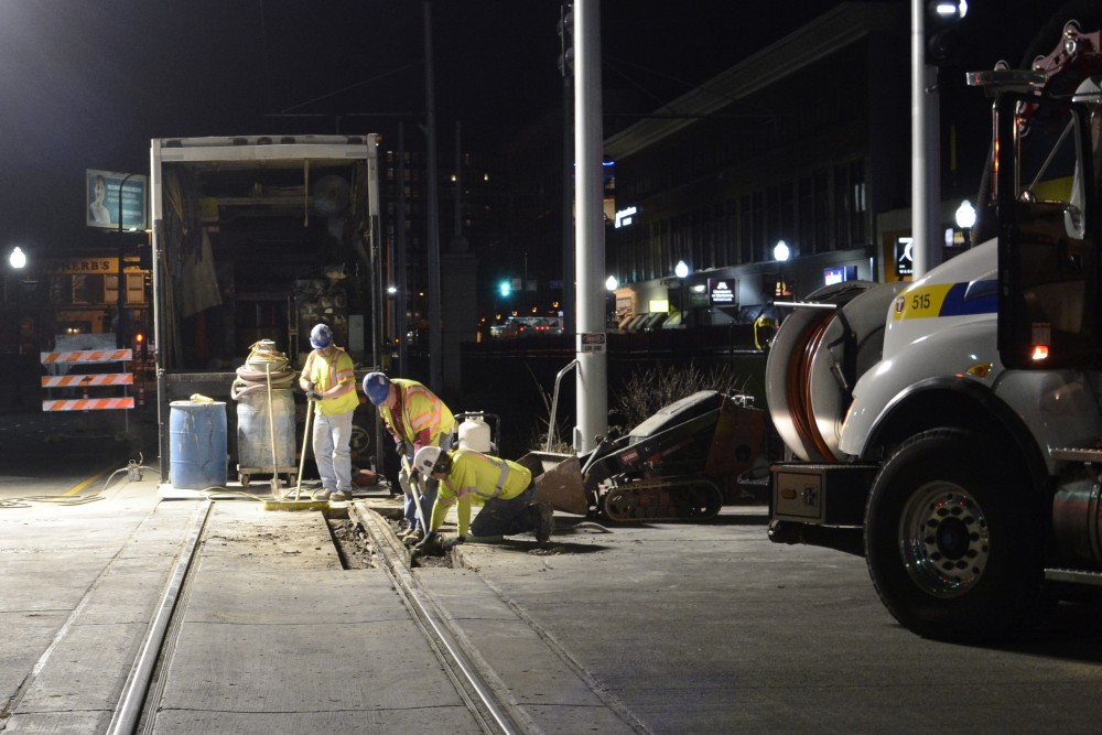 Construction workers preform routine maintenance on the light rail tracks in Stadium Village. 