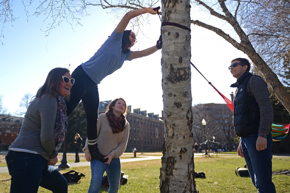 Left to right, freshmen Laura Darling, Nadja Malby, Alison Gould and Grant Zastoupil hang a hammock outside of Territorial Hall in the Superblock on March 24. All four students are residents of dorms on campus.